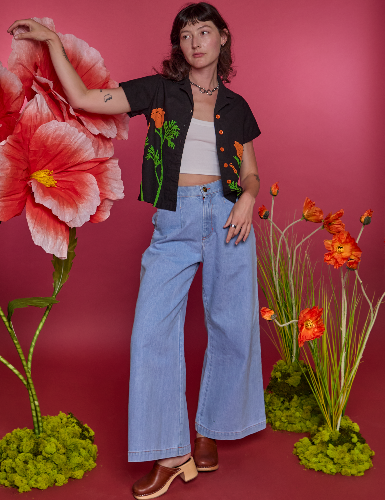 Alex is wearing Paintstamped Pantry Button-Up in Poppy and light wash Indigo Wide Leg Trousers