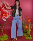 Alex is wearing Paintstamped Pantry Button-Up in Poppy and light wash Indigo Wide Leg Trousers