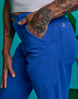 Close up of Jesse's hand in the front pocket of Paintstamped Work Pants in Daisy