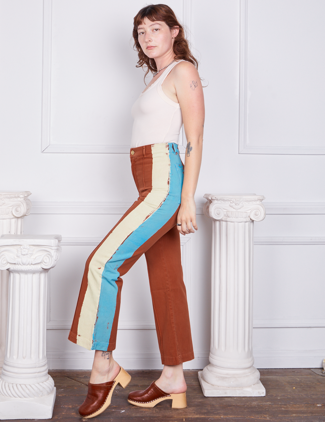 Side view of Hand-Painted Stripe Western Pants in Burnt Terracotta and vintage off-white Tank Top worn by Alex