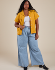 Meghna is wearing Pantry Button-Up in Mustard Yellow and light wash Indigo Wide Leg Trousers