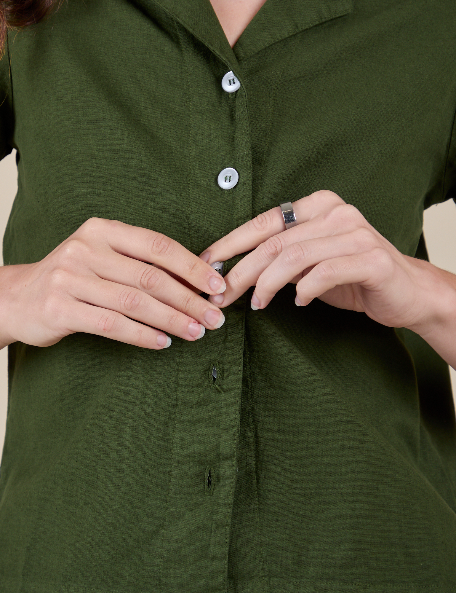 Alex is buttoning up the Pantry Button-Up in Evergreen