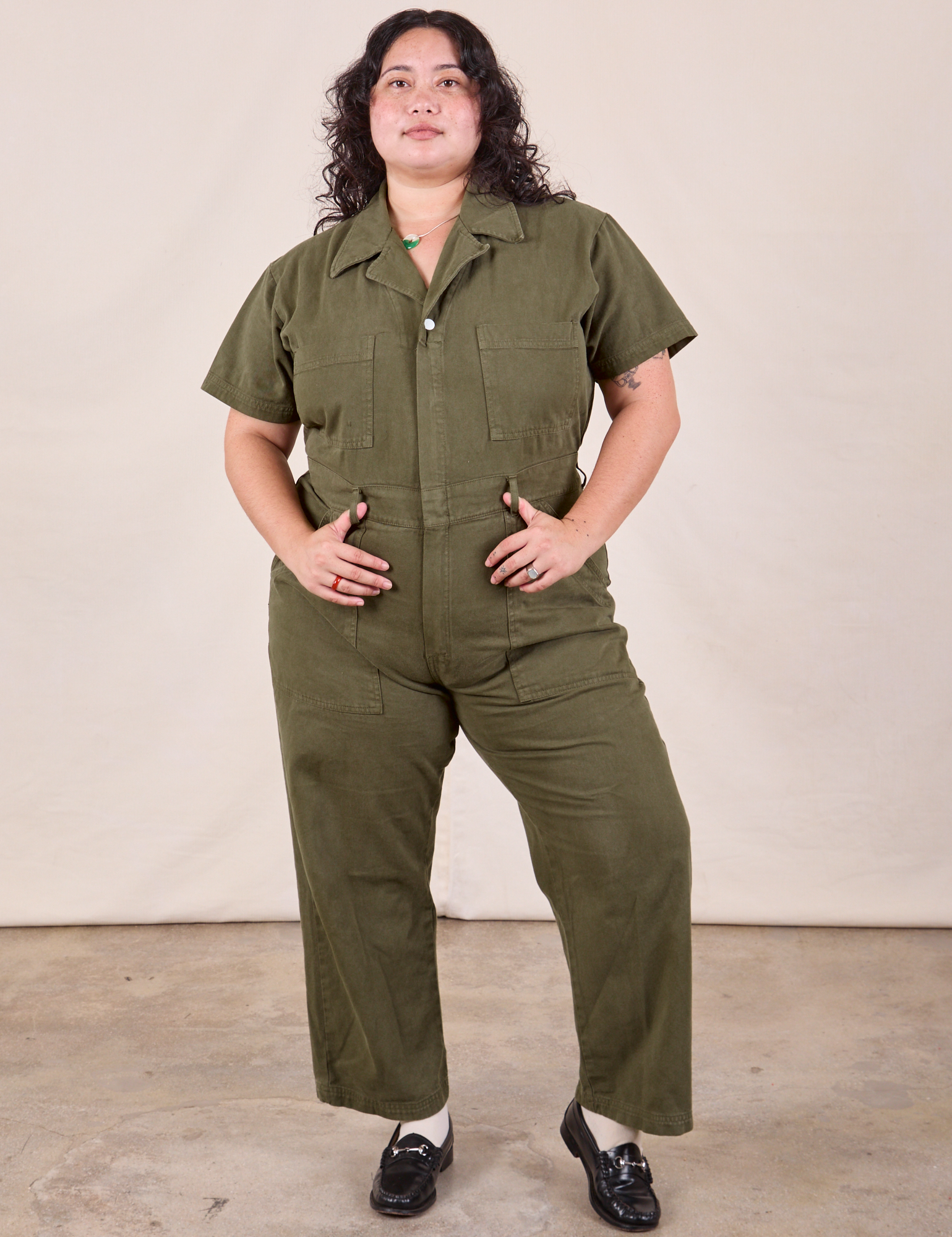 Ari is wearing Petite Short Sleeve Jumpsuit in Surplus Green