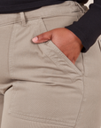 Front pocket close up of Work Pants in Khaki Grey. Worn by Morgan with her hand in the pocket