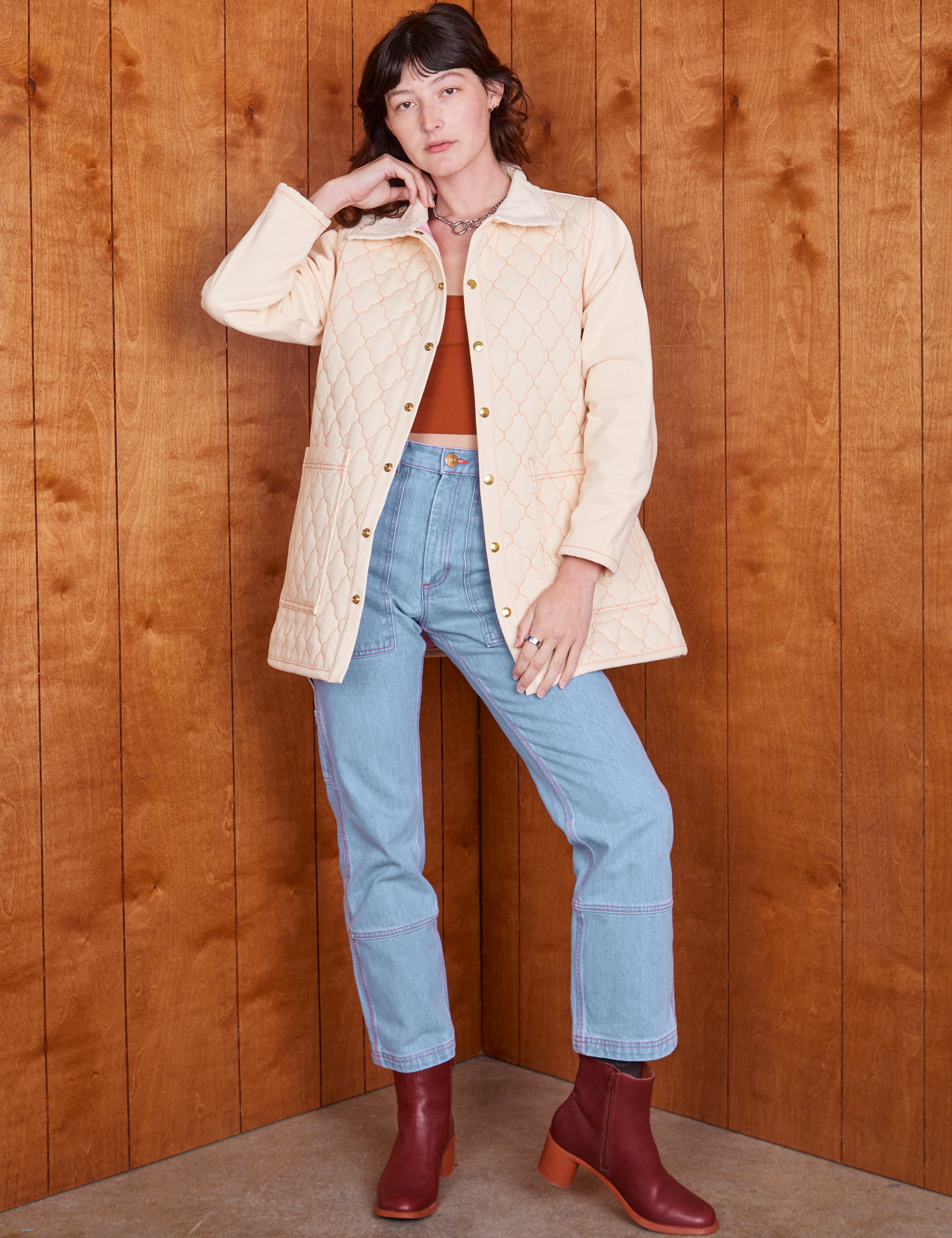 Alex is wearing Quilted Overcoat in Vintage Off-White and light wash Carpenter Jeans