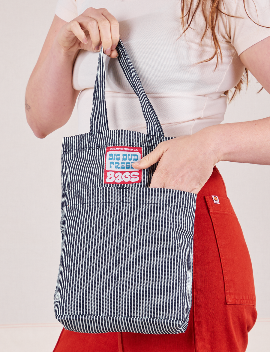 Railroad Stripe Denim Mini Tote held by model with hand in the front pocket