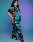 Angled front view of Short Sleeve Jumpsuit in Rainbow Magic Waters on Ashley.