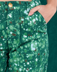 Front pocket close up of Marble Splatter Work Pants in Hunter Green. Scarlett has her hand in the pocket.
