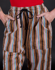 Striped Drop Pocket Pants in Retro Rainbow front close up with Alex's hand in both pockets
