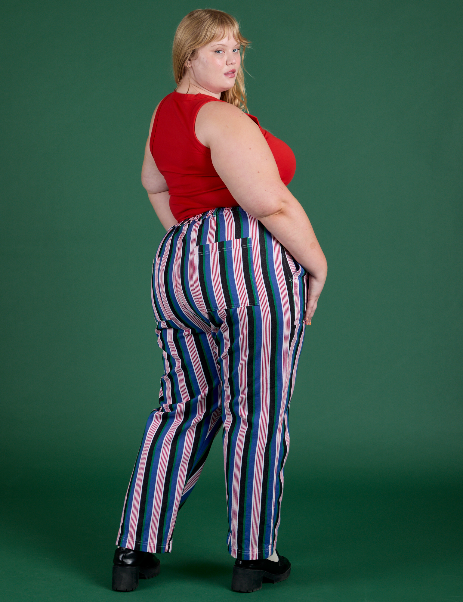 Angled back view of Work Pants in Pacific Stripe and mustang red Cropped Tank on Juliet