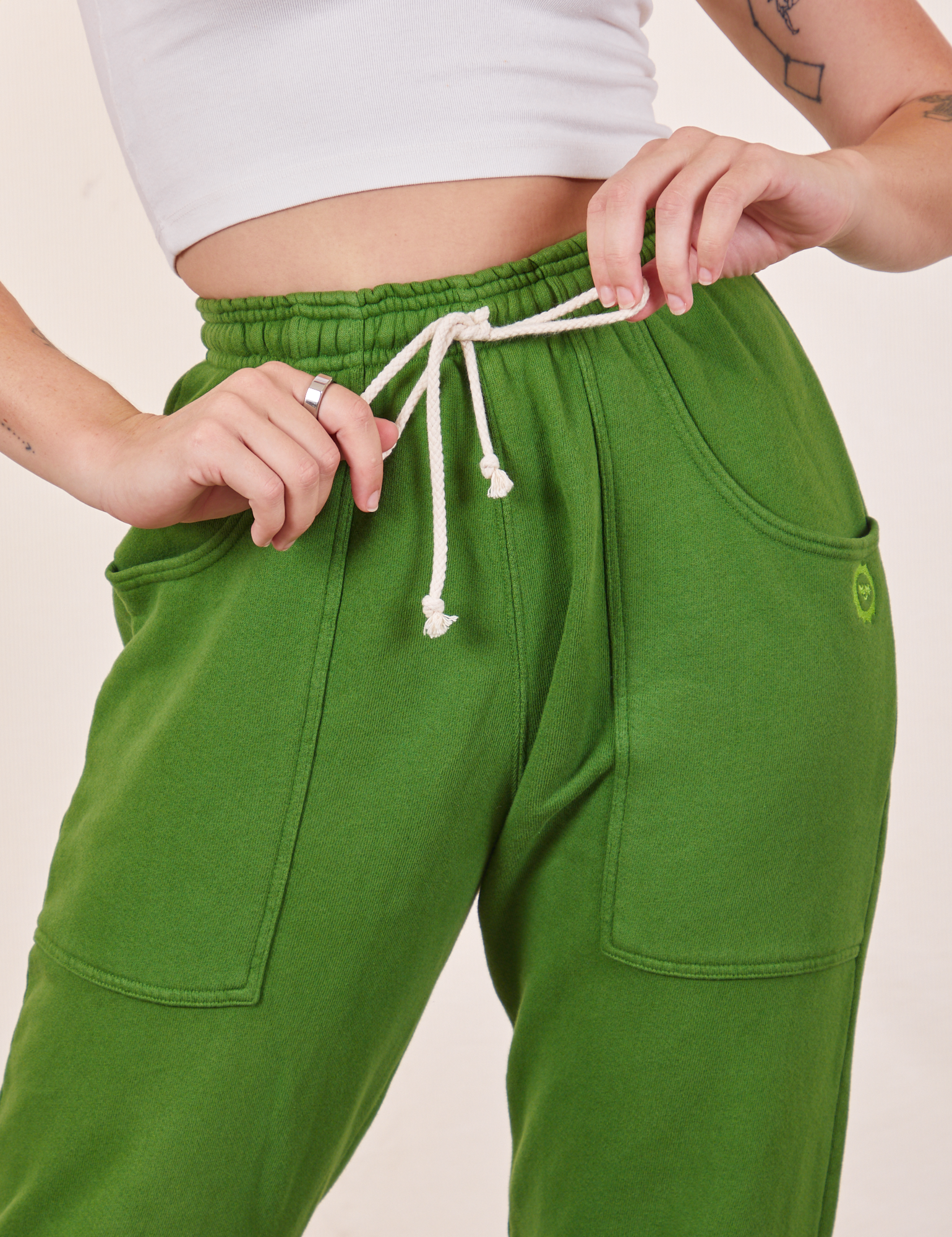 Cropped Rolled Cuff Sweatpants in Lawn Green front close up on Alex