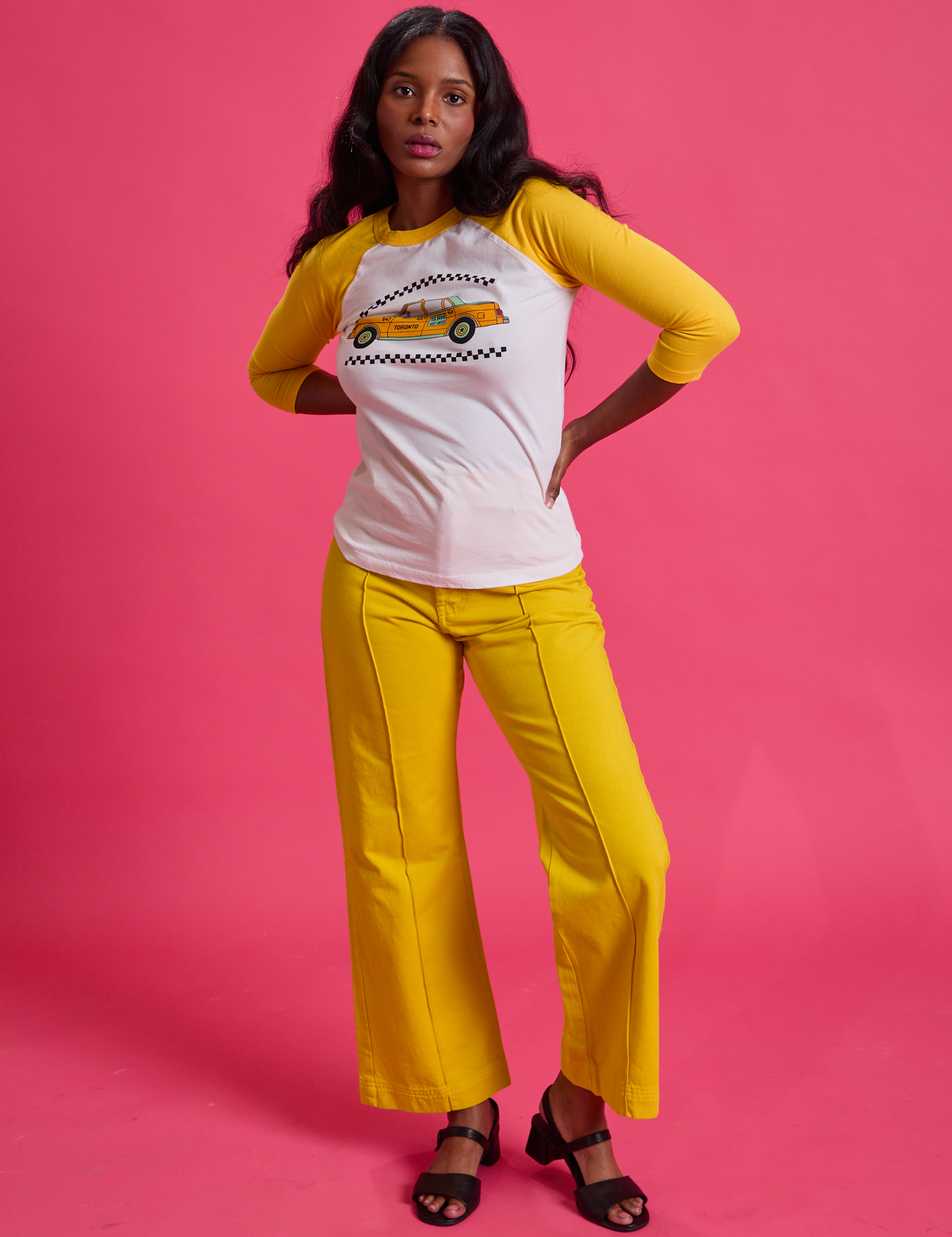 Kandia is wearing Taxi Raglan Tee in Toronto and golden yellow Western Pants