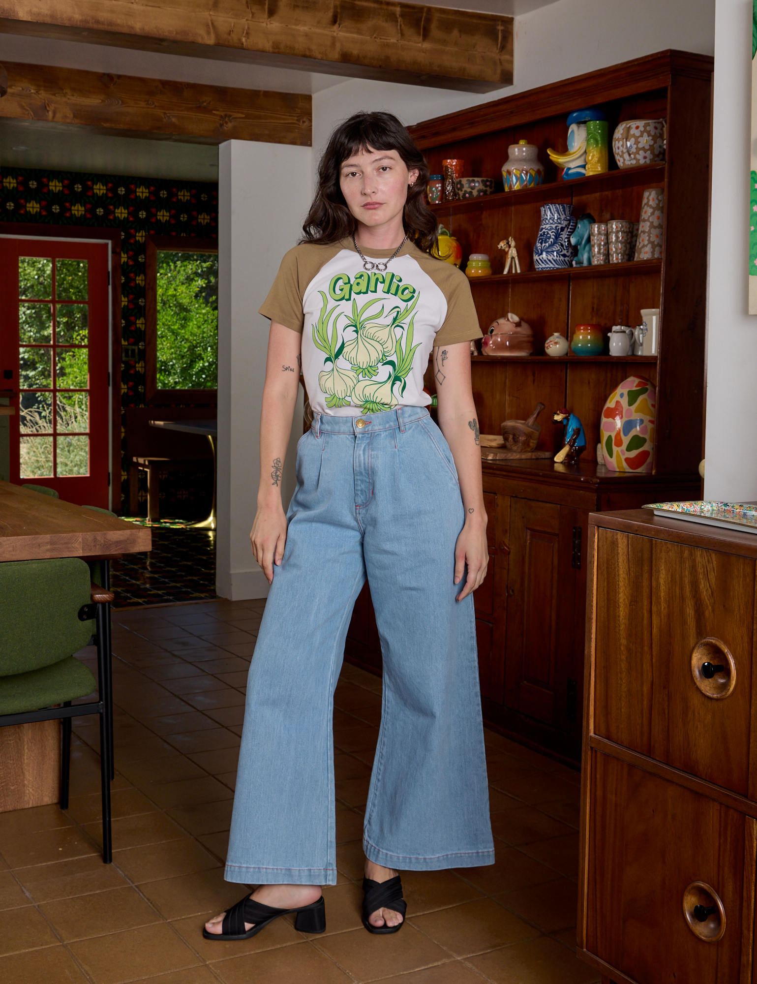 Alex is wearing Short Sleeve Raglan Tee in Garlic tucked into light wash Indigo Wide Leg Trousers