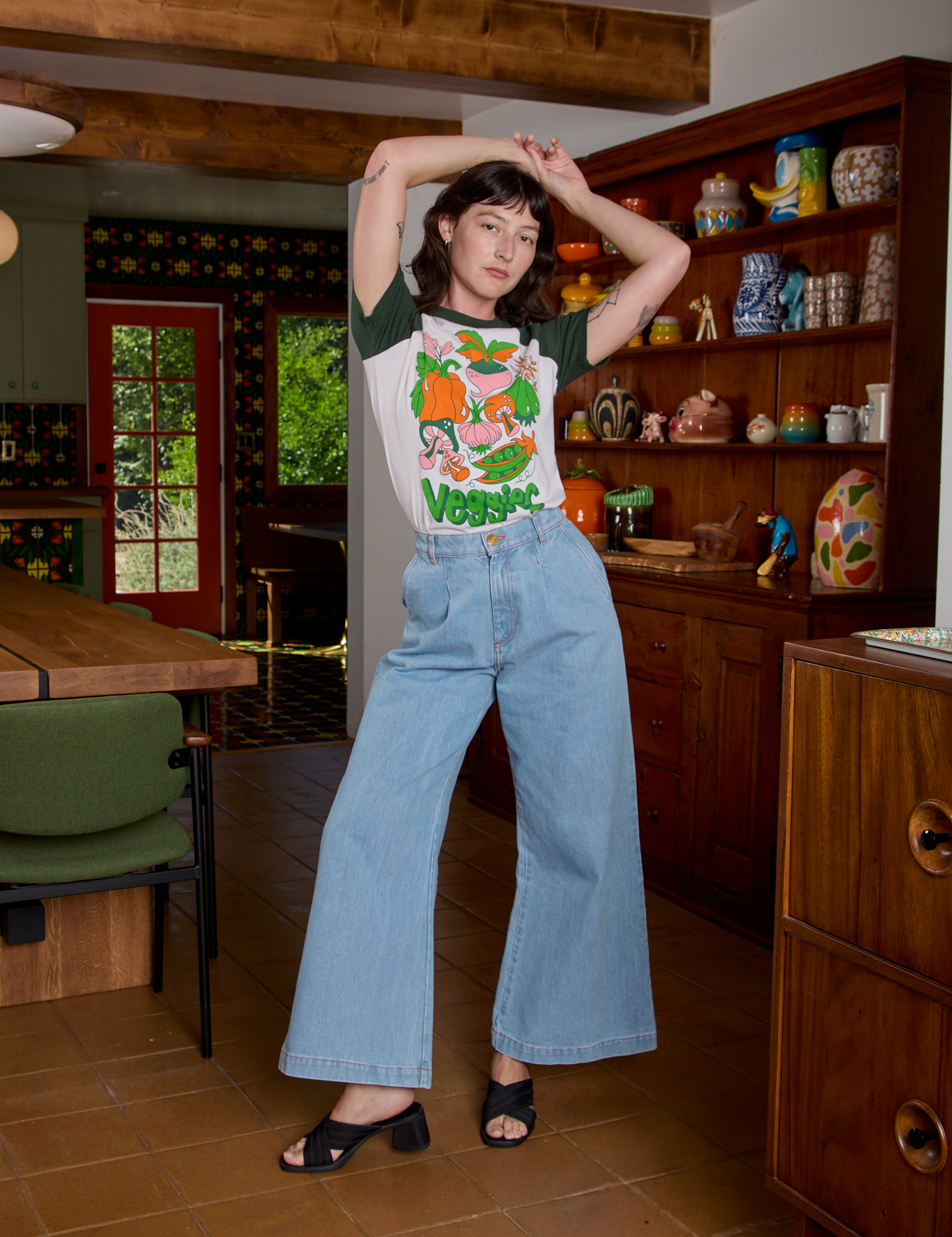 Alex is wearing Short Sleeve Raglan Tee in Veggies tucked into light wash Indigo Wide Leg Trousers