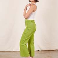 Side view of Western Pants in Gross Green paired with vintage off-white Tank Top worn by Soraya