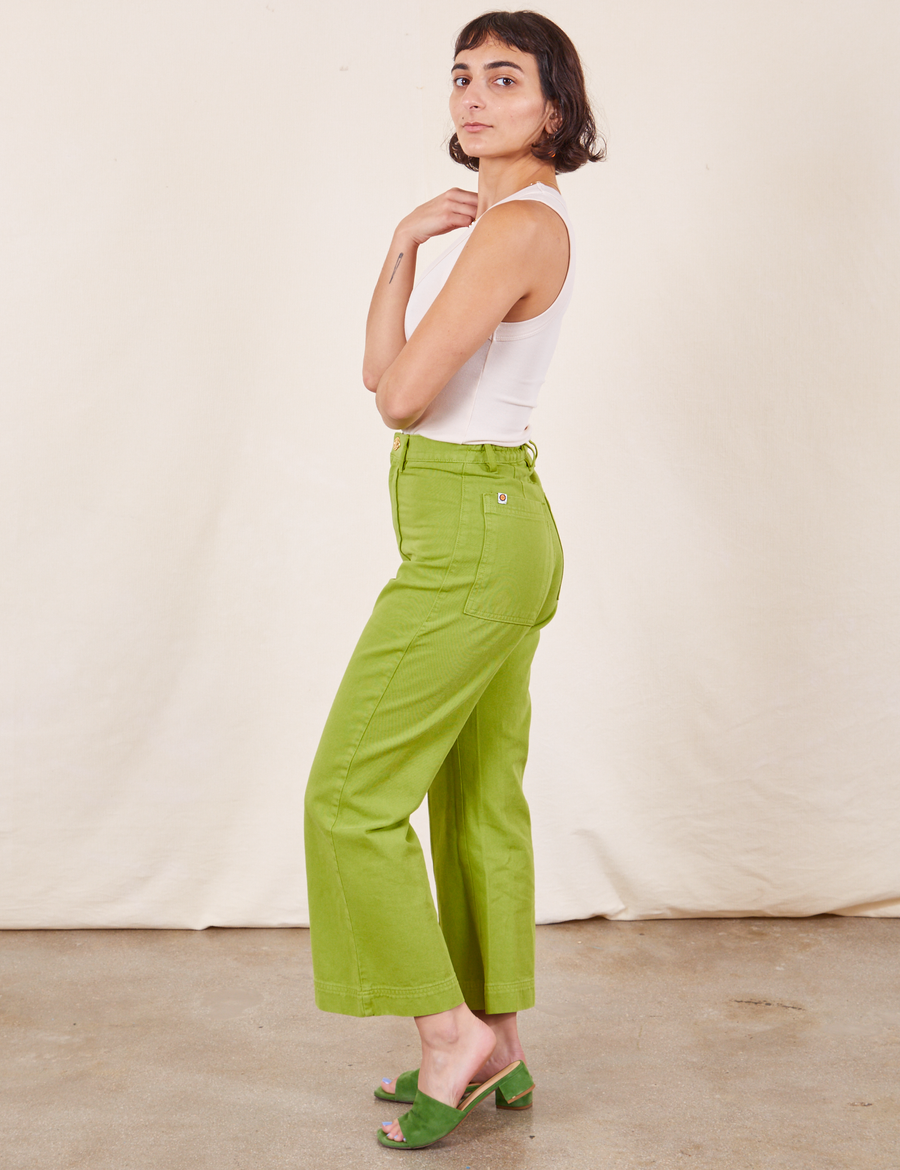 Side view of Western Pants in Gross Green paired with vintage off-white Tank Top worn by Soraya