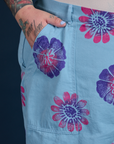 Close up of Sam's hand in the front pocket of Floral Painted Work Pants in Blue