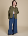 Hana is wearing Denim Work Jacket in Surplus Green and dark wash Indigo Wide Leg Trousers