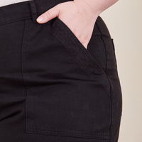 Ashley has her hand in the front pocket of Work Pants in Basic Black
