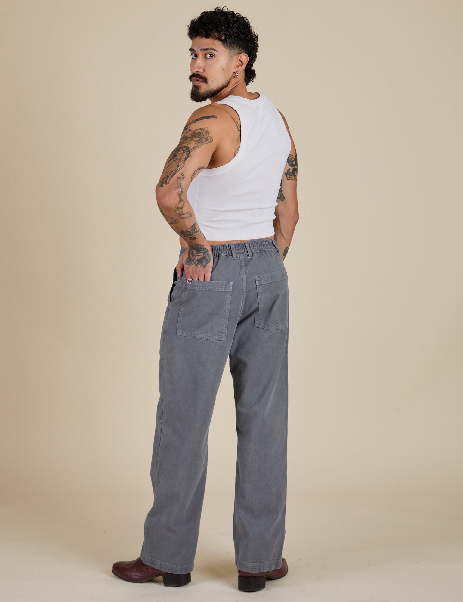 Angled back view of Work Pants in Washed Grey and vintage tee white Cropped Tank on Jesse