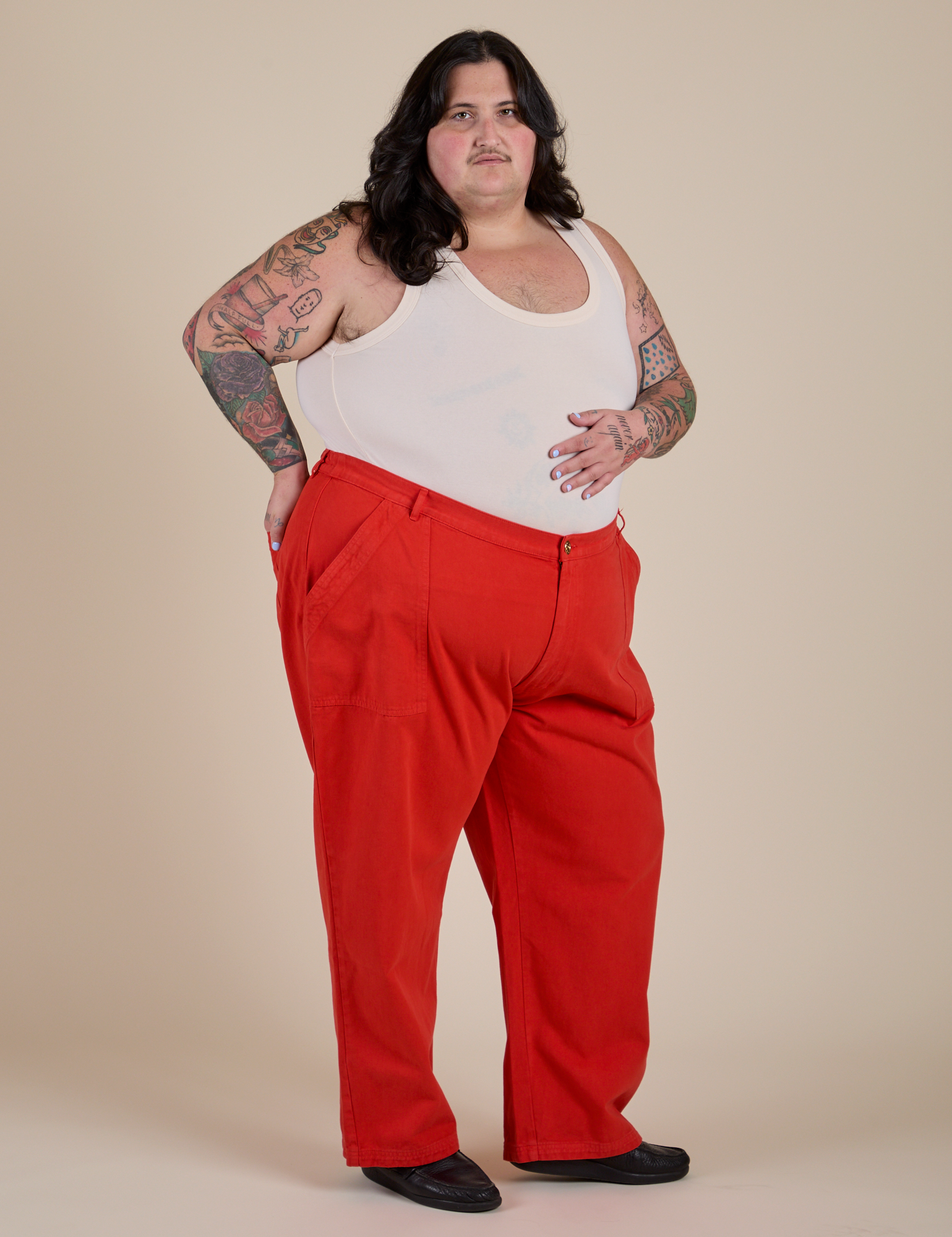 Angled front view of Work Pants in Mustang Red and Cropped Tank in Vintage Tee White on Sam