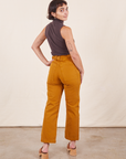 Work Pants in Spicy Mustard back view on Soraya wearing a espresso brown Sleeveless Turtleneck