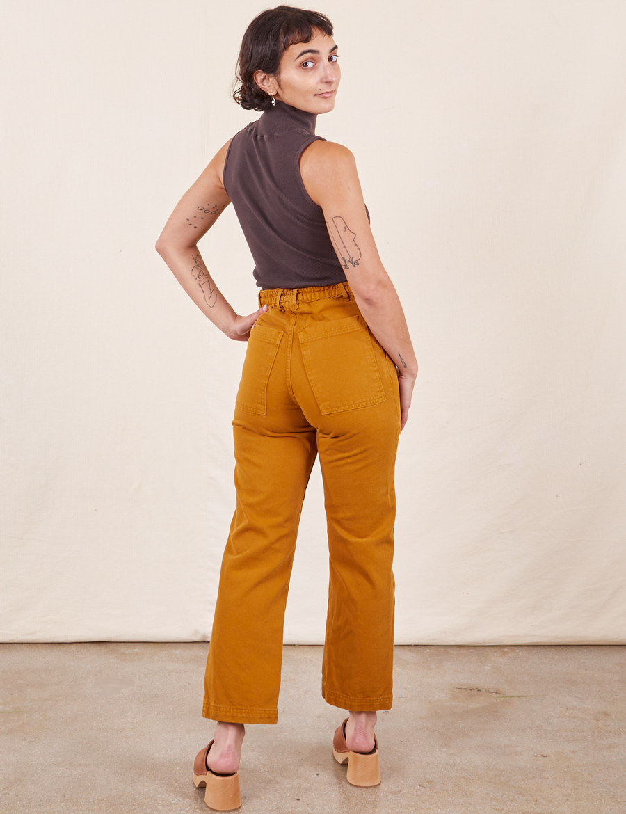 Work Pants in Spicy Mustard back view on Soraya wearing a espresso brown Sleeveless Turtleneck