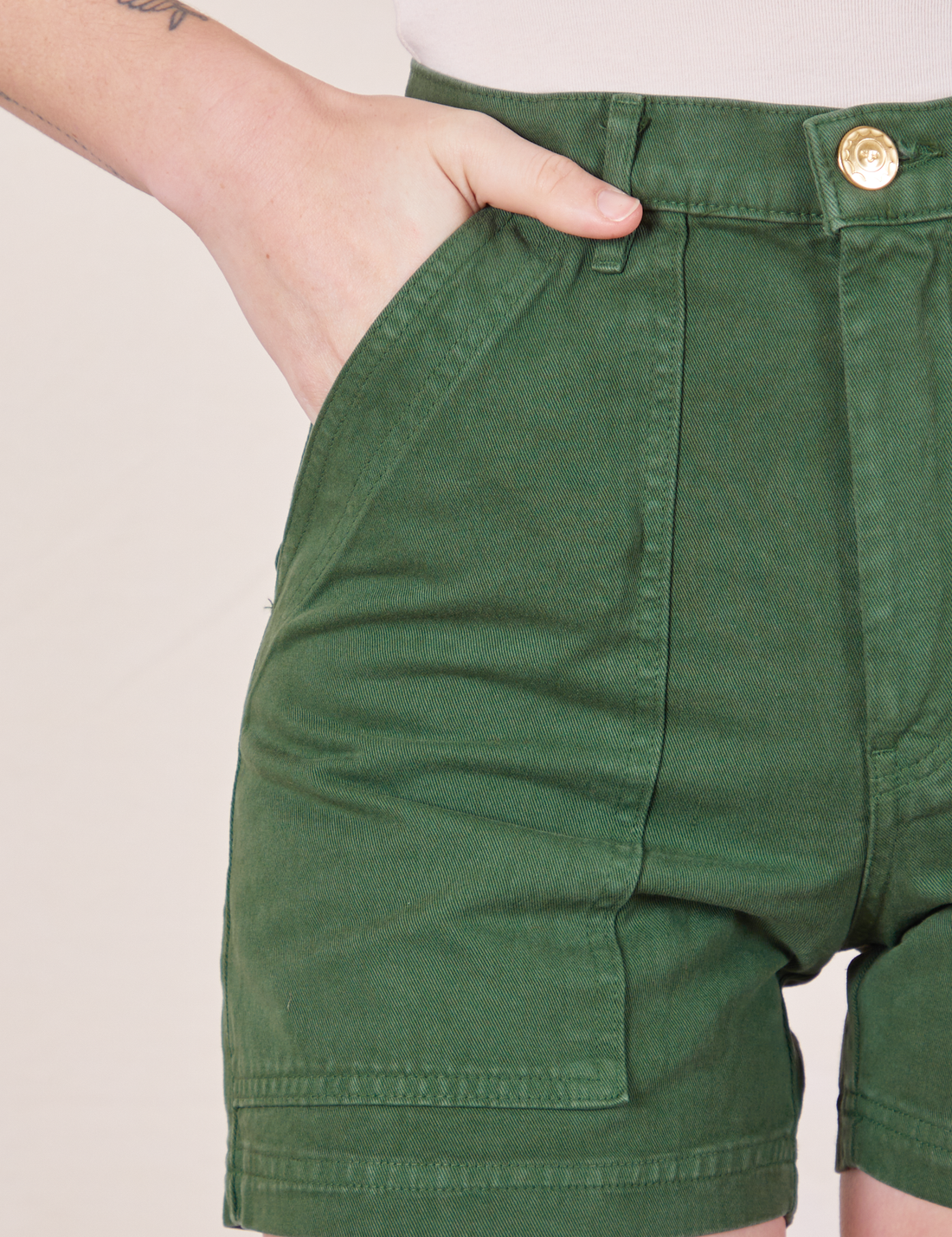 Classic Work Shorts in Dark Emerald Green front pocket close up. Alex has her hand in the pocket.