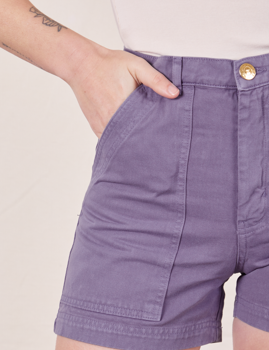 Front pocket close up of Classic Work Shorts in Faded Grape. Alex has her hand in the front pocket.