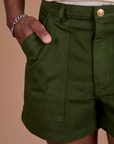 Close up of Isaac's hand in the front pocket of Classic Work Shorts in Evergreen