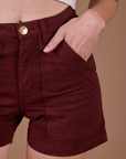 Close up of Alex's hand in the front pocket of Classic Work Shorts in Red Wine