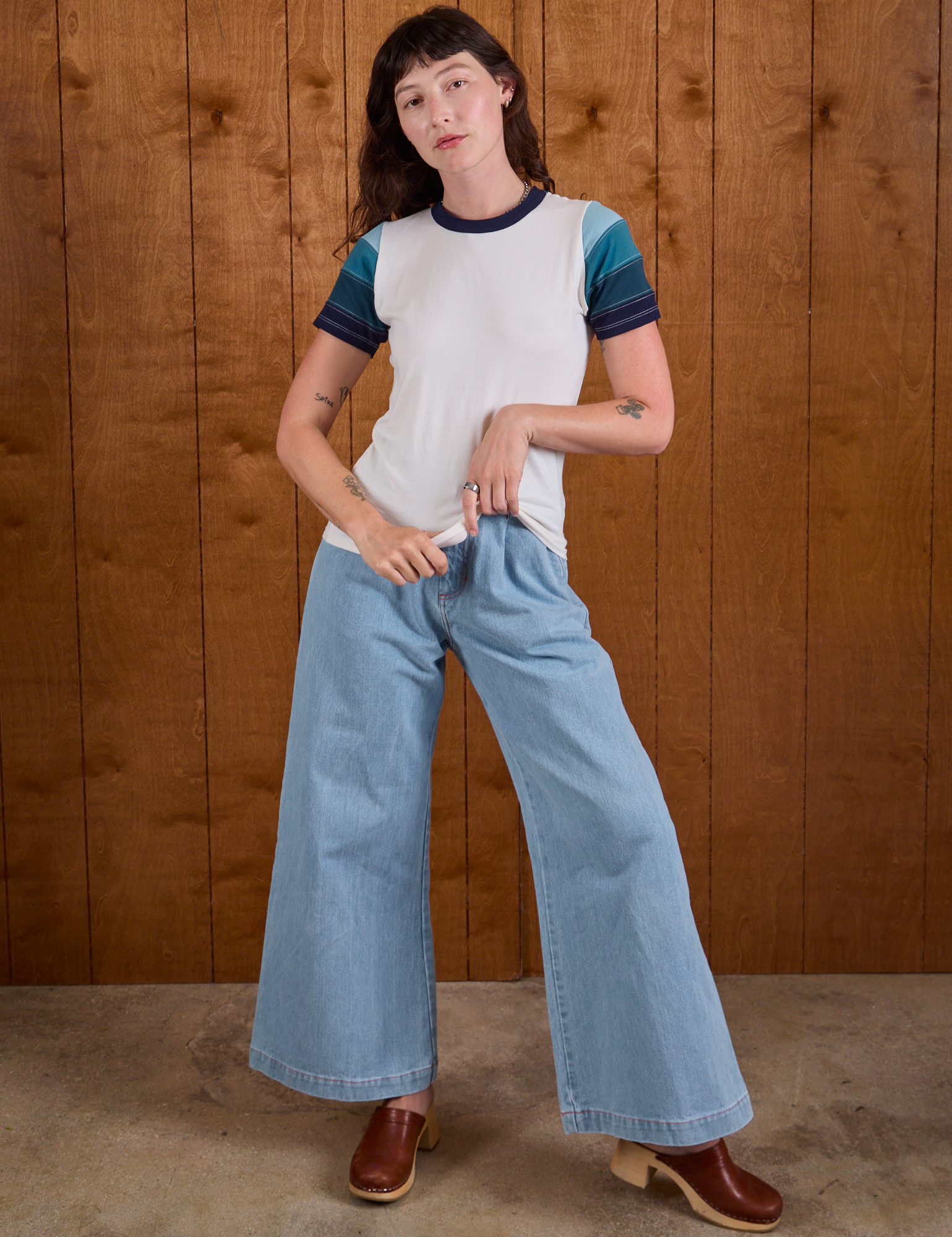 Alex is wearing Calypso Tee in Ocean and light wash Indigo Wide Leg Trousers