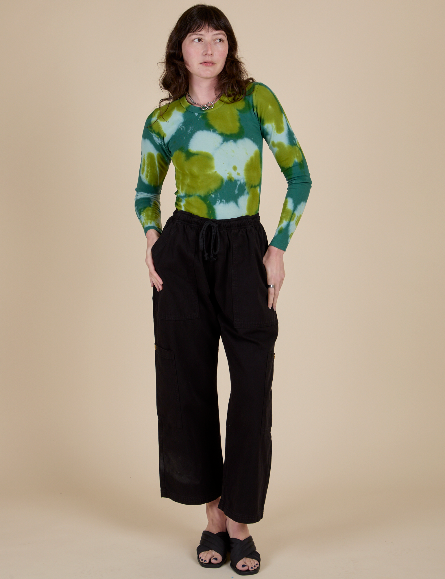 Alex is wearing Long Sleeve Baby Tee in Green Magic Waters and black Drop Pocket Cargo Pants