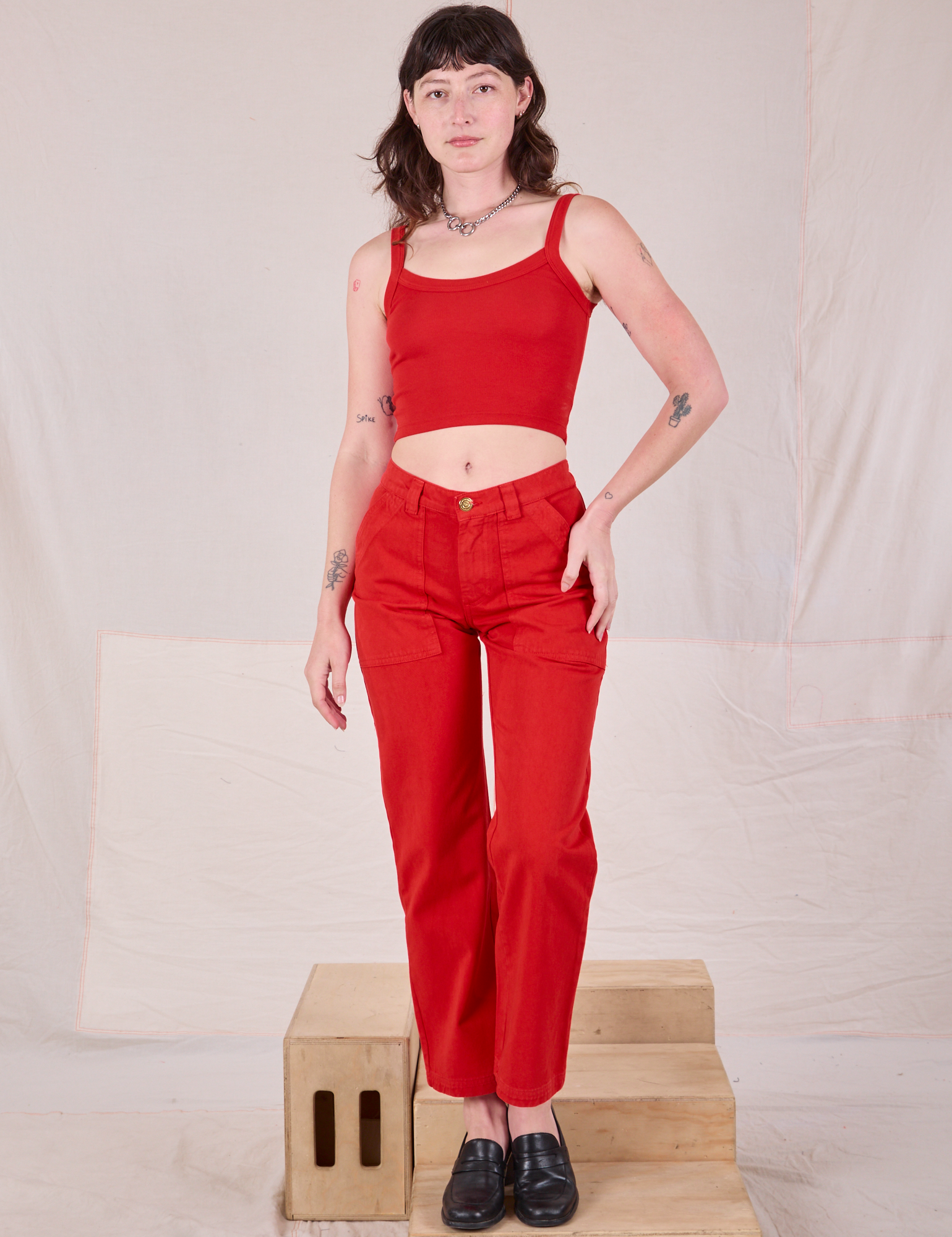 Alex is wearing mustang red Mid-Rise Work Pants in Mustang Red and Cropped Cami