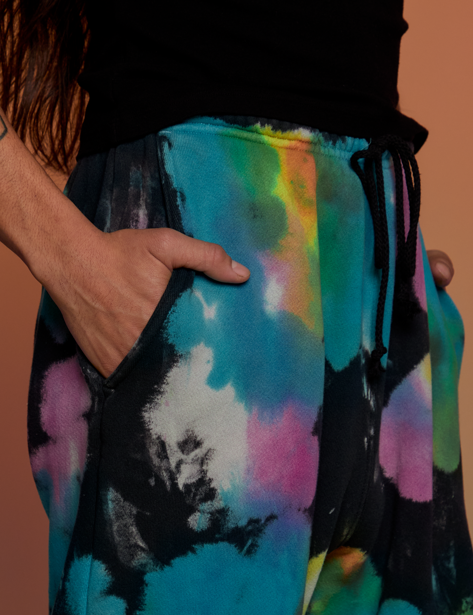 Close up of Anthony&#39;s hand in the pocket of Tie Dyed Wide Leg Sweat Pants