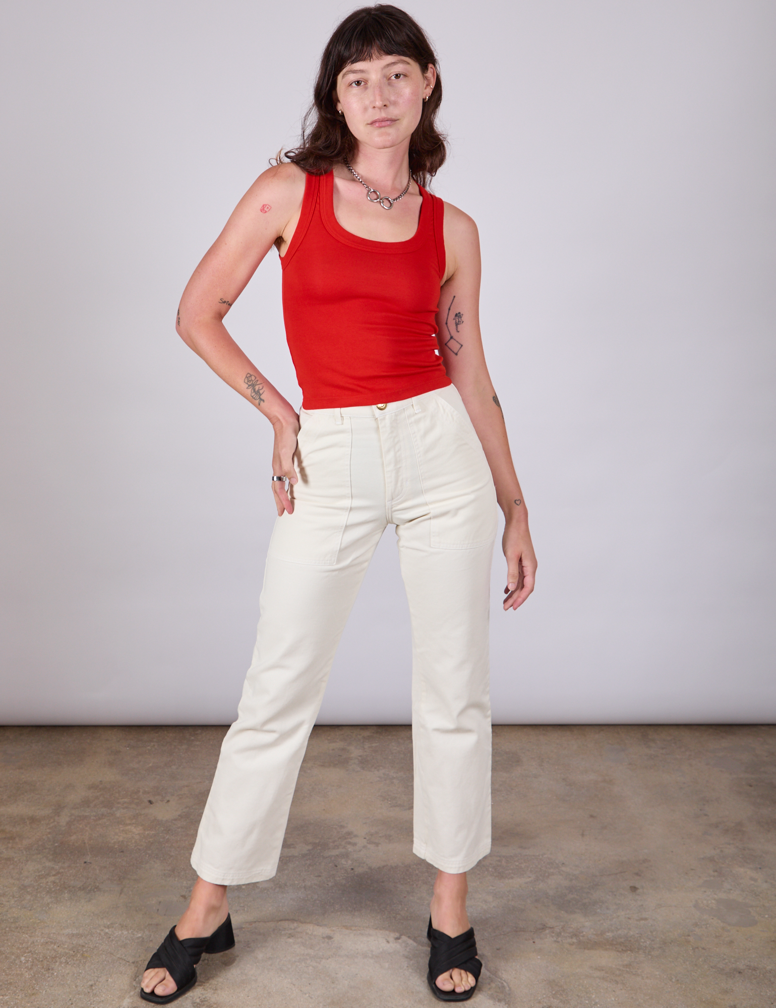 Alex is wearing Tank Top in Mustang Red paired with vintage tee off-white Work Pants