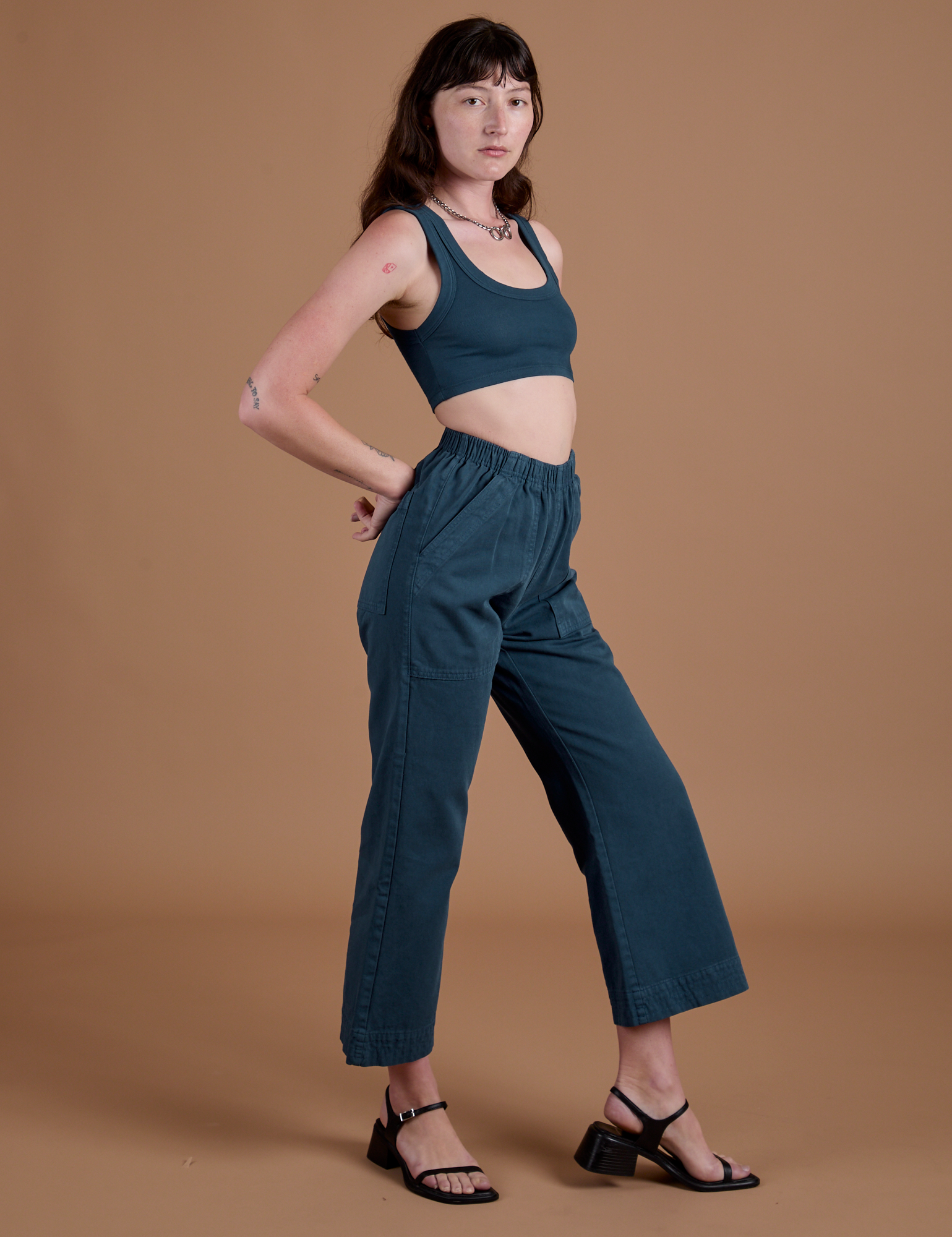 Side view of Action Pants in Lagoon and lagoon Mini Tank on Alex