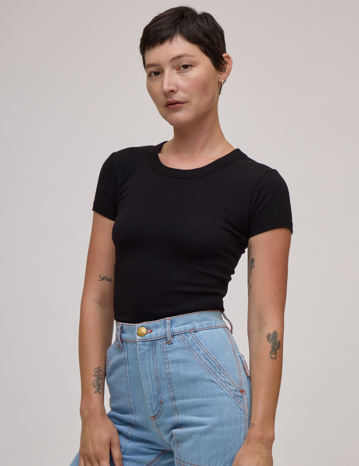 Angled front view of Baby Tee in Basic Black on Alex