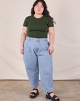 Ashley is wearing Baby Tee in Swamp Green tucked into light wash Denim Trousers