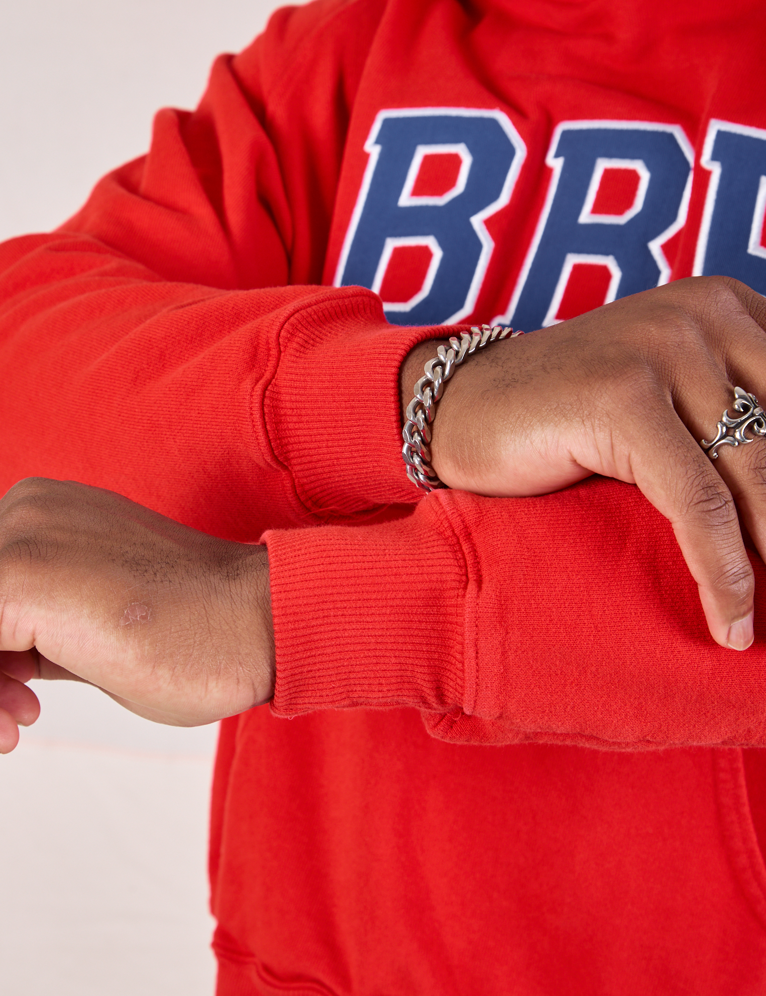 Collegiate Hoodie in Mustang Red sleeve cuff close up on Issac