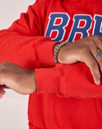 Collegiate Hoodie in Mustang Red sleeve cuff close up on Issac