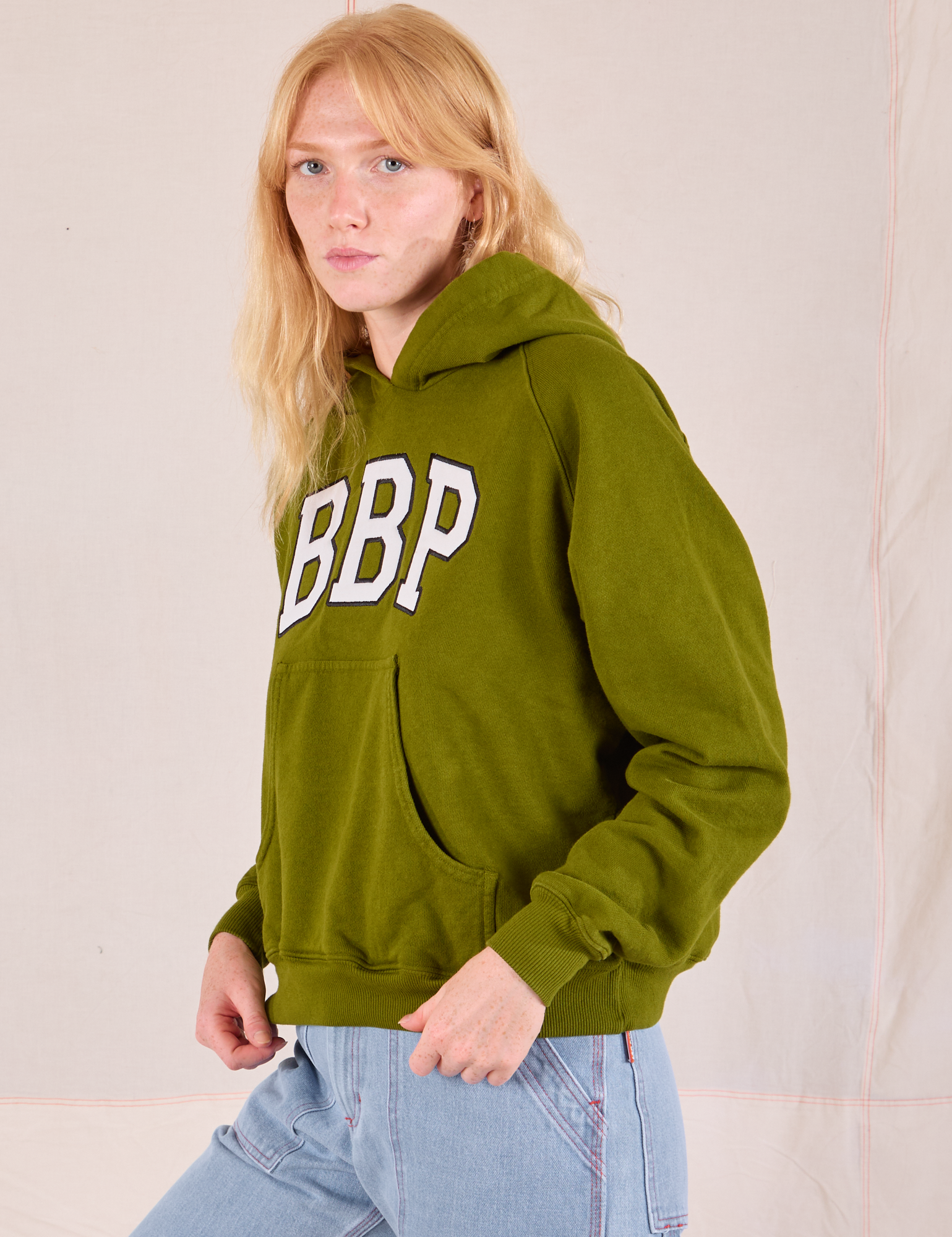 Collegiate Hoodie in Summer Olive side view on Margaret