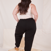 Back view of Denim Trouser Jeans in Black and vintage off-white Tank Top worn by Ashley
