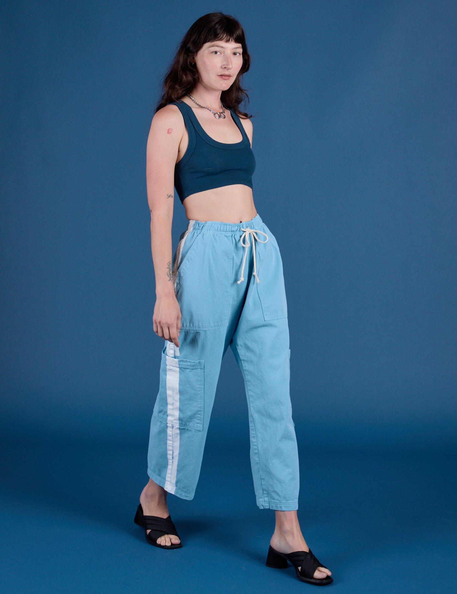 Angled front view of Painted Drop Pocket Cargo Pants in Baby Blue and lagoon Mini Tank on Alex