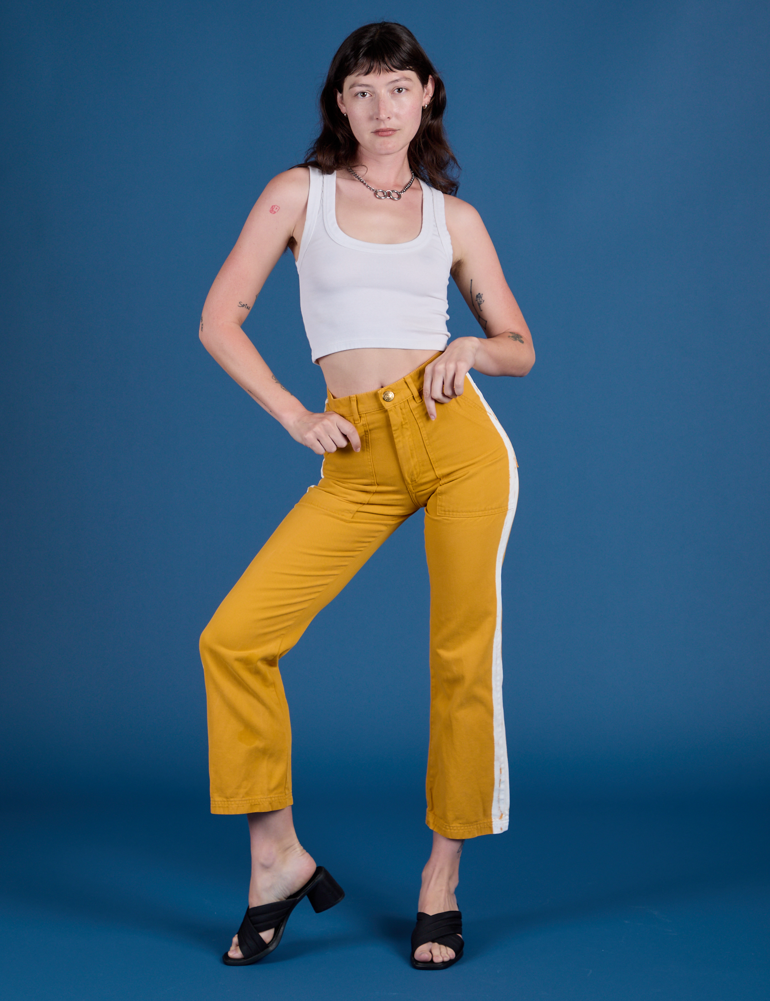 Alex is wearing Painted Work Pants in Mustard Yellow and Cropped Tank in Vintage Tee White