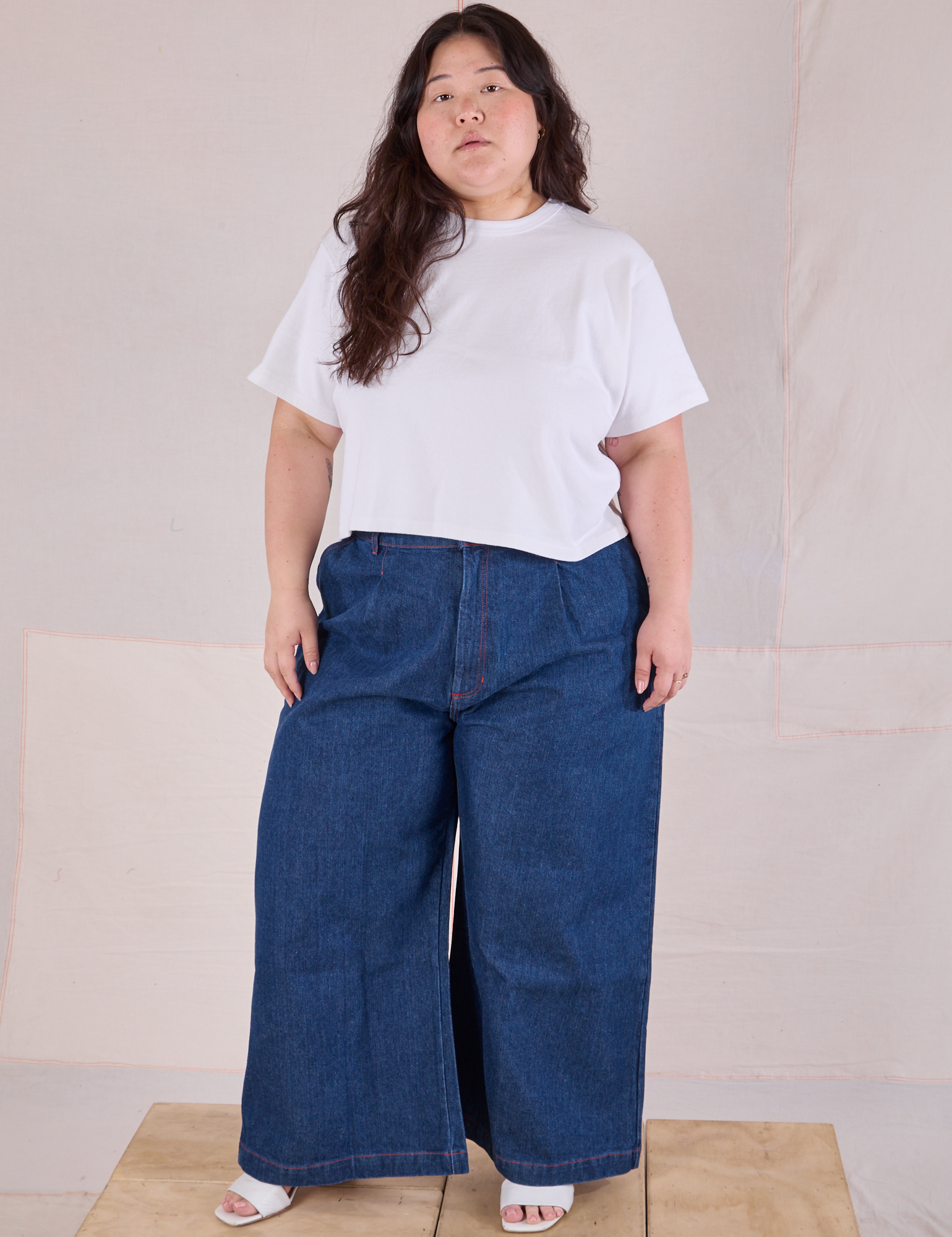 Ashley is wearing Cropped Burly Tee in Vintage Tee White and dark wash Indigo Wide Leg Jeans