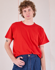 Quinn is wearing Burly Tee in Mustang Red tucked into dark wash Denim Trousers