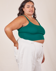 Angled view of Cropped Cami in Hunter Green and vintage off-white Western Pants worn by Alicia
