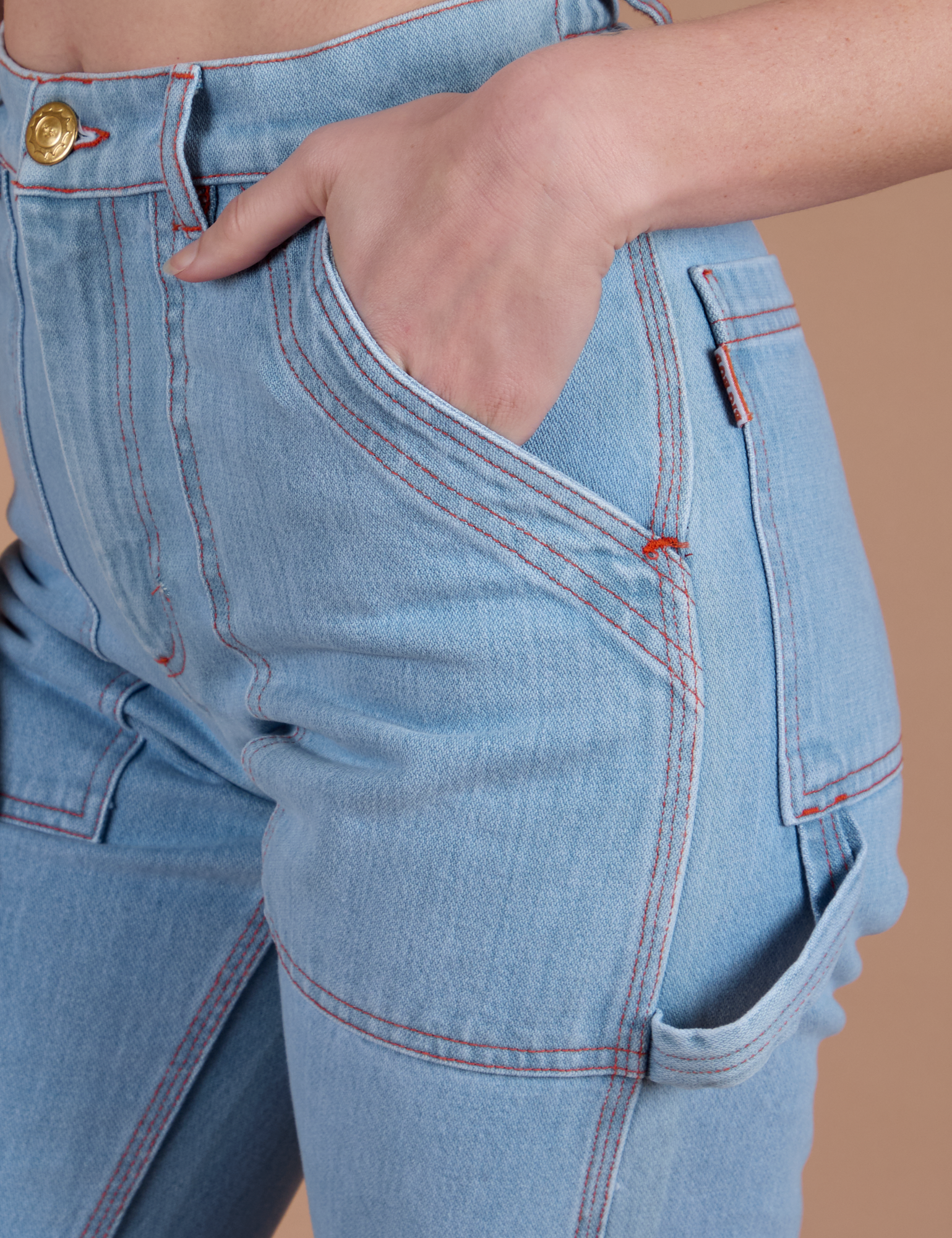 Close up of Alex's hand in the front pocket of Carpenter Jeans in Light Wash