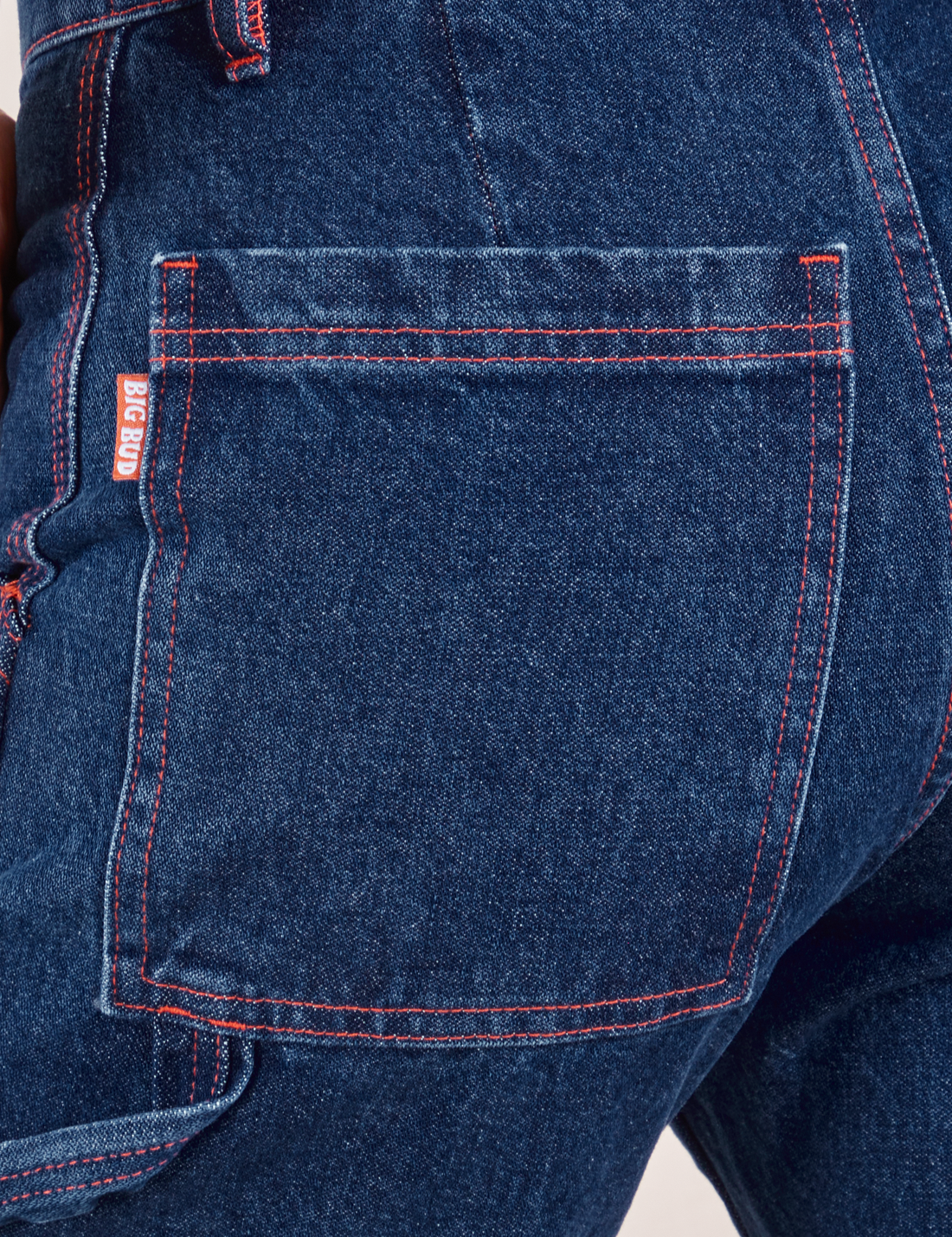 Carpenter Jeans in Dark Wash back pocket close up. Red contrast stitching on pocket and near seams.
